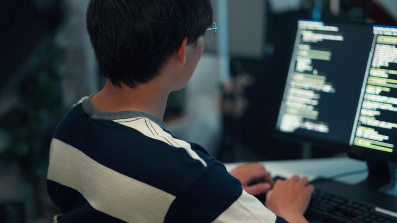 developer debugging code on screen - Back view programmer typing code dual screen monitor application ...